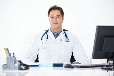 Confident doctor sitting at his office desk