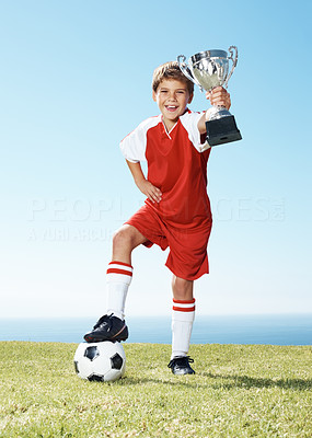 Excited little football champion with his winners trophy
