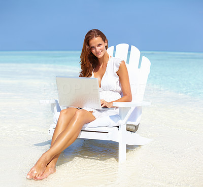 Gorgeous woman using laptop on beach