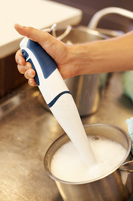 Chef using hand blender in kitchen