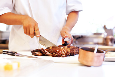 Professional chef cutting roasted meat