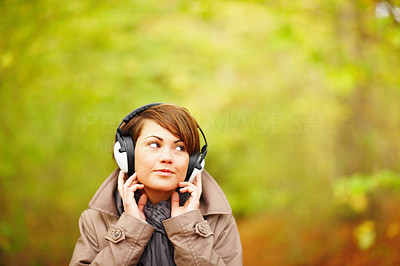 Woman listening to music outside in Autumn