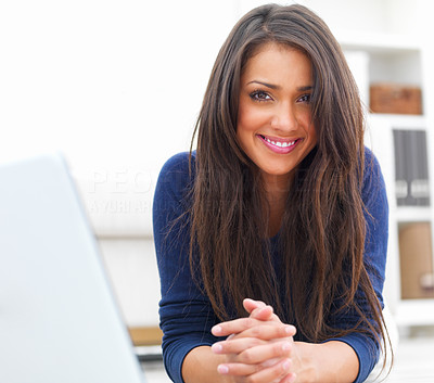Portrait of a young pretty lady lying by a laptop