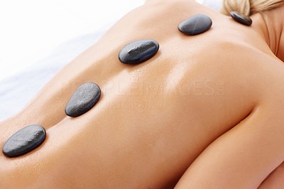 Cute image of a female getting a stone massage therapy