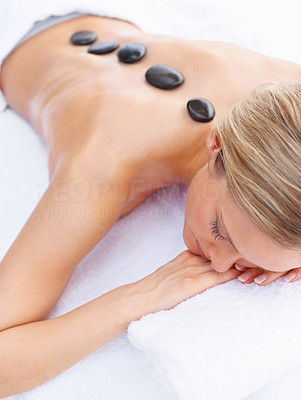 Woman receiving a hot stone treatment at the dayspa