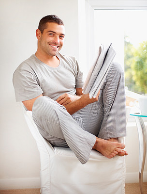 Happy young man reading newspaper - Indoor