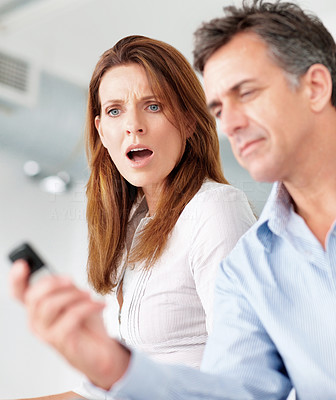 Business woman looking shocked at colleague\'s cellphone