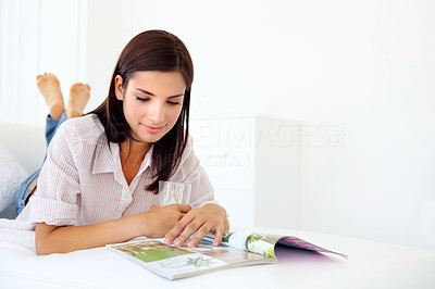 Happy young woman reading a magazine