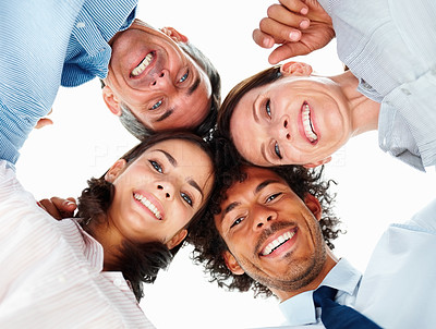 Upward view of a group of happy business colleagues with their heads together
