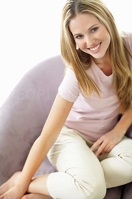 Happy relaxed woman sitting on couch and smiling