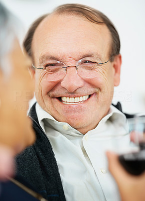 Happy senior man having a glass of wine with wife