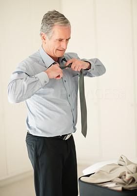 Senior business man taking off his tie