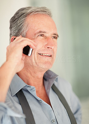 Happy senior business man speaking over cell phone