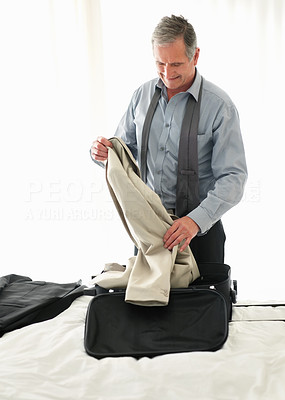 Happy mature man preparing for business trip