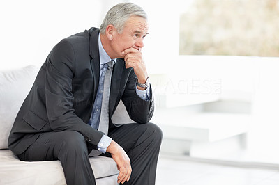 Frustrated business manager sitting on sofa - copyspace