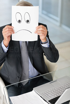 Mature man holding a sad sign on sheet of paper over his face