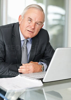 Tired business man at a table with laptop trying to keep awake