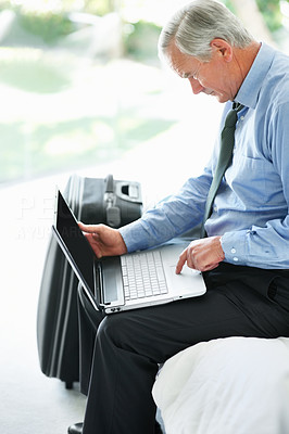 Relaxed senior business man working on a laptop
