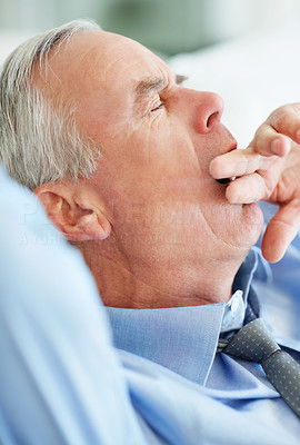 Closeup of a sleepy senior business man yawning