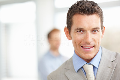 Smiling business executive with a blurred man in background