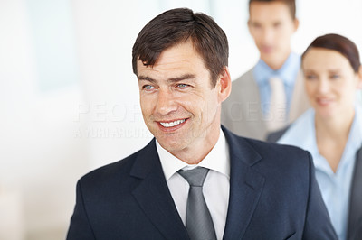 Happy middle aged man with his associates in background