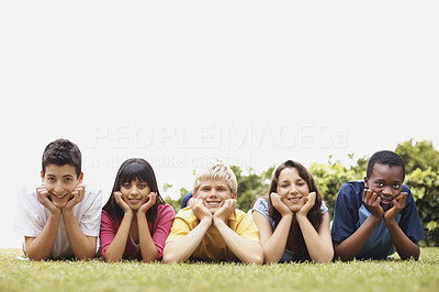 Teenagers lying relaxed on grass in a line with copyspace