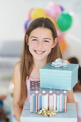 Cute little girl at a birthday party with gift boxes