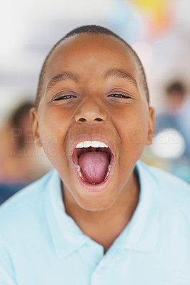 Closeup of a little boy screaming with his mouth opened