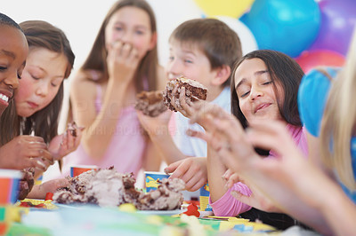 Cute children enjoying the birthday cake at a party