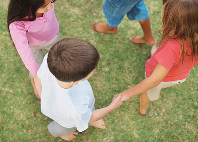 Top view of playful kids holding hands in a circle