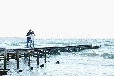 Couple holding hands and walking on a jetty