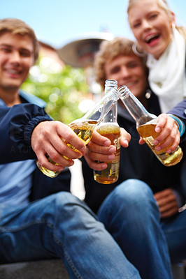 Young boys and girls toasting beer bottles