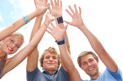 Closeup of young men and woman raising hands