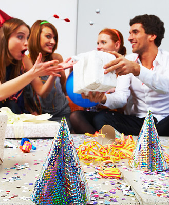 Surprised birthday woman after receiving gifts and party hats on table