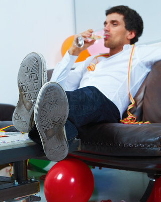 Relaxed young boy drinking champagne on the couch