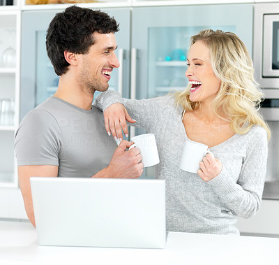 Happy romantic couple using a laptop and having coffee