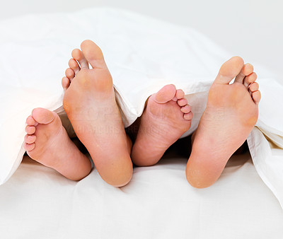 Couple\'s feet in bed sleeping besides each other