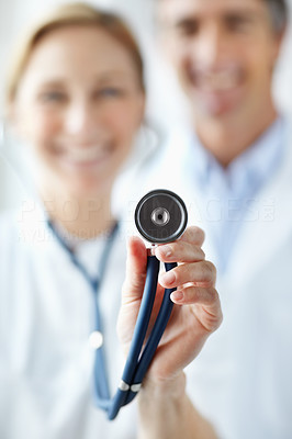 Image of a stethoscope being held by a nurse and doctor