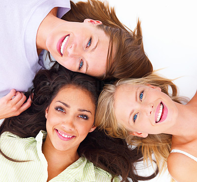 Closeup portrait of happy young friends lying together on white background