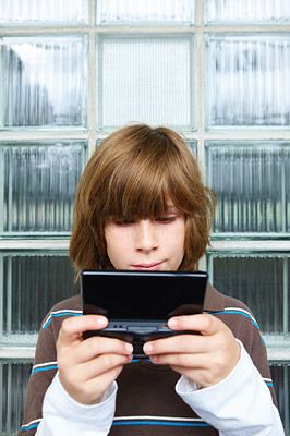 Closeup of a boy playing video game with glass in background