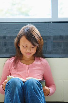 Closeup of a happy girl reading a book