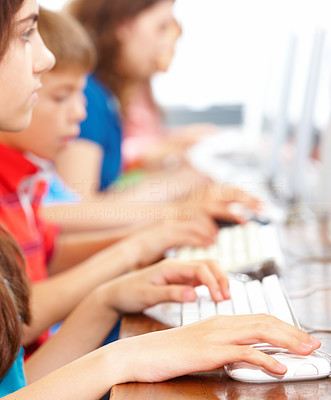 Small girl using computer with children in background
