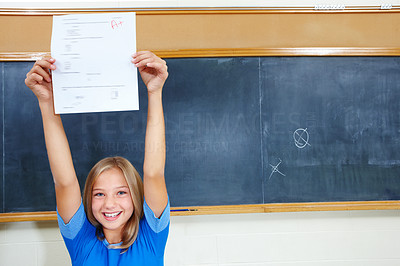 Closeup of a happy young girl showing exam results with pride