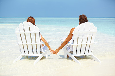 Loving couple relaxing on deck chairs