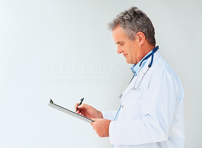 Mature doctor making a report on a notepad