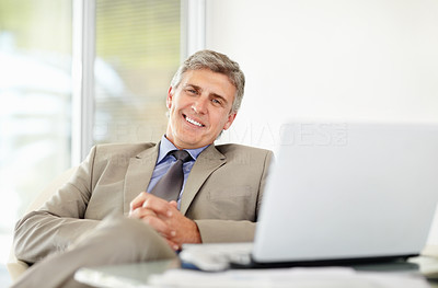 Relaxed mature business man with laptop at office