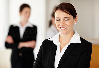 Successful young business girl with her team in blur background