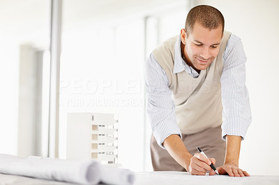 Middle aged architect drawing a plan in office