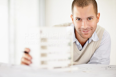 Smiling middle aged architect holding his building model