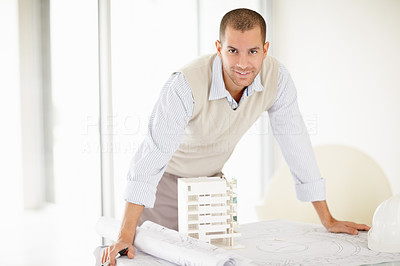 Successful architect with his building model and design